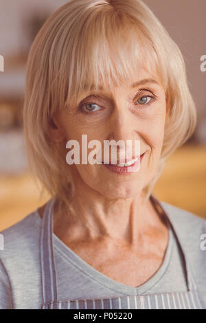 Portrait von ziemlich alten Frau in einer Schürze Stockfoto