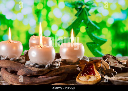 Adventskranz mit brennenden Kerzen vor dem Weihnachtsbaum Stockfoto