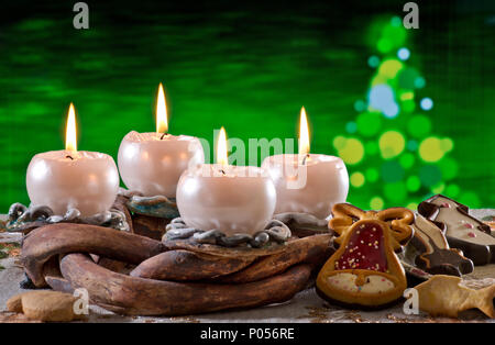 Adventskranz mit brennenden Kerzen vor dem Weihnachtsbaum Stockfoto