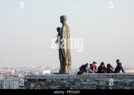 Touristen in der Nähe der Bronze Statue der Jungfrau Mary von Bildhauer Laszlo Matyassy außerhalb der Budaer Burg, mit Blick auf die Stadt Budapest auf der Donau Stockfoto