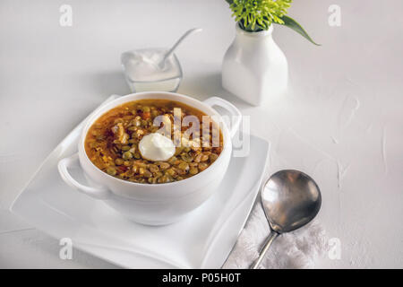 Asiatische traditionelle Linsensuppe mit Tomaten und grünen in einer weißen Schüssel. Serviert werden. Stockfoto