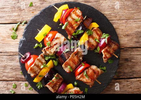 Saftig gegrillte Fleischspieße Schweinefilet mit Tomaten, Paprika, Zwiebeln und Auberginen close-up auf einer Schiefertafel Platte auf einem Tisch. horizontal oben Ansicht von oben Stockfoto