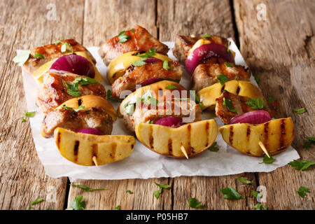 Frisch Schweinefleisch Spieße mit Äpfeln und roten Zwiebeln close-up auf Pergament auf den Tisch vorbereitet. Horizontale Stockfoto