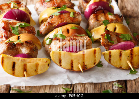 Gegrilltes Schweinefleisch kebabs mit frischen Äpfeln und roten Zwiebeln auf Spieße close-up auf dem Tisch. Horizontale Stockfoto