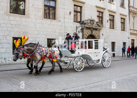 Krakau, Polen - 21. April 2017: Pferde mit Pferdekutschen in der Altstadt in Krakau. Krakau ist die zweitgrößte und eine der ältesten Städte in Stockfoto