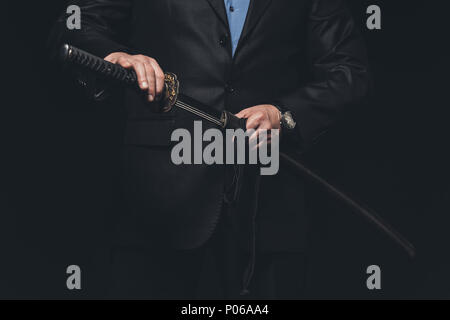 7/8 Schuß von Mann in Anzug, aus seinem Katana Schwert auf Schwarz isoliert Stockfoto