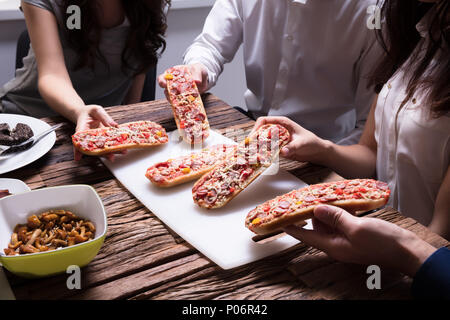 In der Nähe von Freunden Kommissionierung Scheibe Bruschetta über Holz- Tabelle Stockfoto