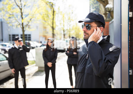 Nahaufnahme eines jungen männlichen Sicherheitsbeamten Hören mit Headset Stockfoto