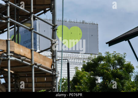 Shepherds Bush, London, UK. 9. Juni 2018. Grenfell Turm ist jetzt voll abgedeckt, grüne Herzen Abdeckung oben, zusammen mit dem Ausdruck "Grenfell für immer in unseren Herzen', mit dem ersten Jahrestag der Brand in der nächsten Woche. Quelle: Matthew Chattle/Alamy leben Nachrichten Stockfoto