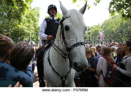 London, UK, 9. Juni 2018. Die jährliche die Farbe in London zu Ehren von Königin Elizabeth's Geburtstag übernommen hat. Tausende säumten die Straßen ihrer Majestät und die anderen Mitglieder der Königlichen Familie zu begrüßen, da sie mit dem Bus von Buckingham Palace auf Horse Guards Parade gereist. Hier ein Polizist auf dem Pferderücken ebnet einen Weg durch die Menge. Credit: Clearpix/Alamy leben Nachrichten Stockfoto