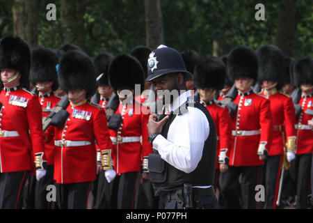 London, UK, 9. Juni 2018: Ein schwarzer Metropolitan Police Officer von Hunderten von Wachposten entlang der Mall marschieren die Horse Guards Parade Ground, wie sie ihren Weg in die Horse Guards Parade Ground am 9. Juni 2018. Über 1400 paradieren Soldaten, 200 Pferde und 400 Musiker kommen zusammen, jeweils im Juni in einer großen Anzeige der militärischen Präzision, horsemanship und Fanfare offiziellen Geburtstag der Königin zu markieren. Quelle: David Mbiyu Stockfoto