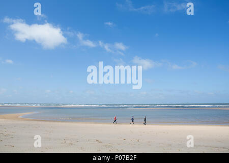 3 entfernten Menschen Spaziergang entlang der Küste bei Holkham Bay, North Norfolk Stockfoto