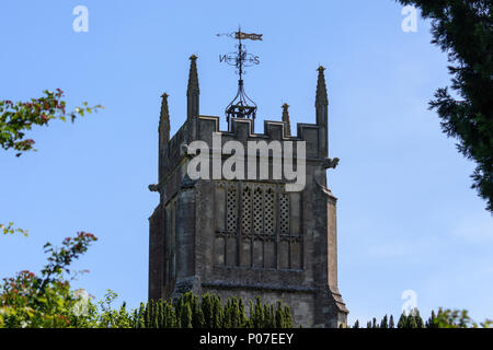 Quadrat flach Dach Kirchturm mit fancy Wetterfahne über Bäumen vor blauem Himmel Stockfoto