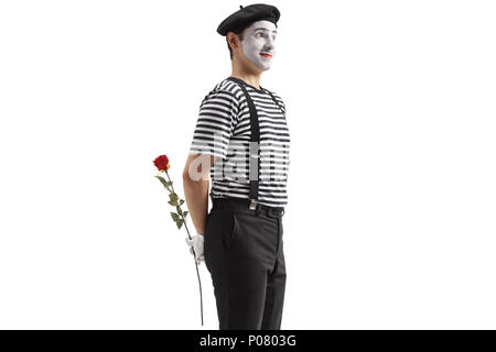 Mime-Holding eine Rose Blume hinter seinem Rücken isoliert auf weißem Hintergrund Stockfoto