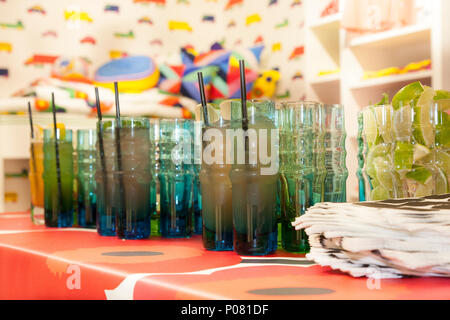 Erfrischende Cocktails in Designer Brille auf eine Bar in einem bunten Shop warten auf Gäste. Stockfoto