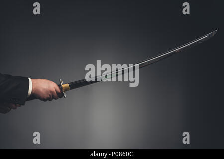 7/8 Schuß von Mann mit Katana Schwert auf Schwarz Stockfoto