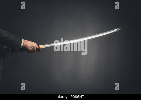 7/8 Schuß von Mann mit Katana auf Schwarz Stockfoto