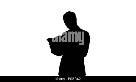 Silhouette Studentin mit Buch auf dem Laptop. Stockfoto