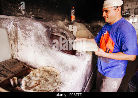 Erbil Erbil Governorate, Region Kurdistan im Irak: Bäcker Koch Fladenbrot in einem traditionellen Backofen in der Altstadt von Erbil. Stockfoto