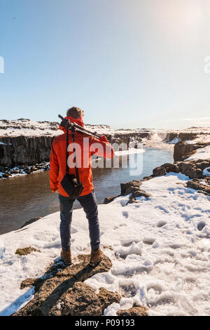 Mann mit Kamera Ausrüstung des Selfoss Wasserfall im Winter, Canyon suchen, Northern Island, Island Stockfoto