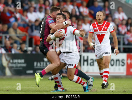 St. Helens' Louie Mc Carthy-Scarsbrook wird durch den Rumpf Kr James Donaldson (Angriff links) Während die Betfred Super League Match an der völlig Gottlosen Stadion, St Helens. Stockfoto