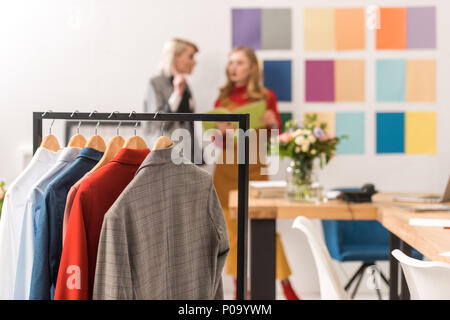 Modische schneiderinnen Arbeiten in modernen Büros mit Kleidung im Vordergrund Stockfoto