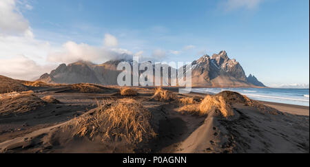 Lange Lavastrand, schwarzer Sandstrand, Dünen bedeckt mit trockenem Gras, Berge, und Eystrahorn Klifatindur Kambhorn Stockfoto