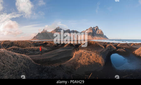 Abendstimmung am langen lavastrand, man zwischen dem schwarzen Sand Dünen mit trockenem Gras bedeckt, Berge Klifatindur Stockfoto