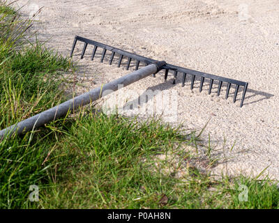 Ein Rake in einem Sandfang auf Musselburgh Links, der alte Golfplatz in Musselburgh, East Lothian, Schottland, eines der ältesten Golfplätze der Welt. Stockfoto