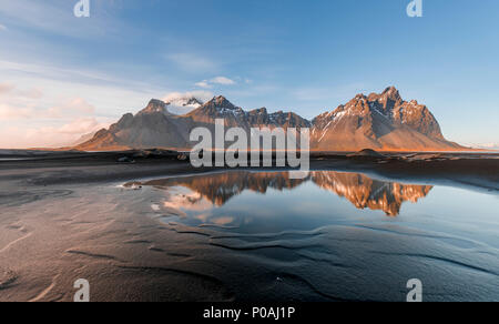 Abendstimmung am langen lavastrand, schwarzer Sandstrand, der Reflexion im Wasser, in den Bergen Klifatindur Stockfoto