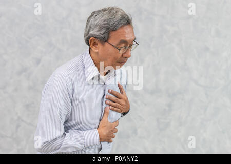 Asiatische Ältere leiden unter Schmerzen in der Brust von Herzinfarkt oder Schlaganfall. Stockfoto