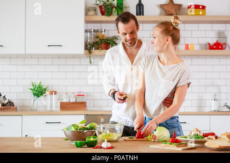 Foto schöne liebevolle Paare Kochen Gemüse in der Küche Stockfoto