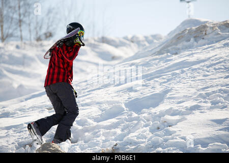 Bild des Menschen mit Snowboard Wandern auf verschneiten Berghang Stockfoto