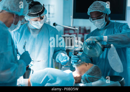 Afrikanische amerikanische Anästhesist holding Sauerstoffmaske Patienten im OP Stockfoto