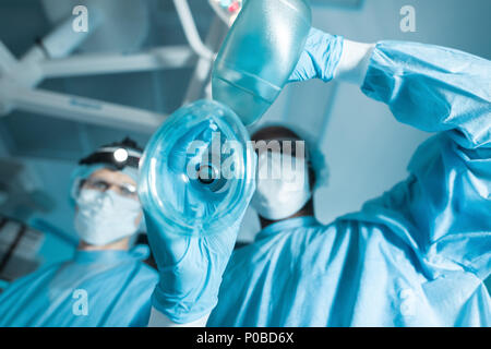 Ansicht von unten auf das afrikanische amerikanische Anästhesist holding Sauerstoffmaske patient Stockfoto