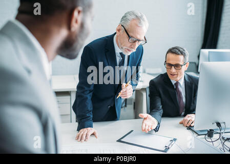 Selektiver Fokus der multiethnischen Kollegen in Treffen im Büro Stockfoto