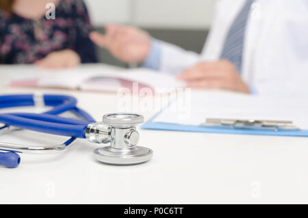 Stethoskop hautnah. Patient und Arzt im Büro. Doktor schreibt das Rezept im Hintergrund Stockfoto