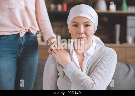7/8 Schuß von Frau Unterstützung von Kranken reife Mutter in das Halstuch bei Camera suchen Stockfoto