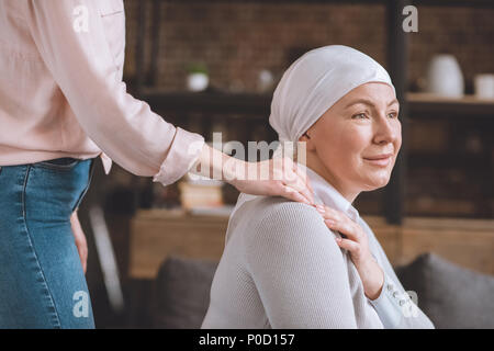 7/8 Schuß von Frau Unterstützung von Kranken reife Mutter in das Halstuch Stockfoto