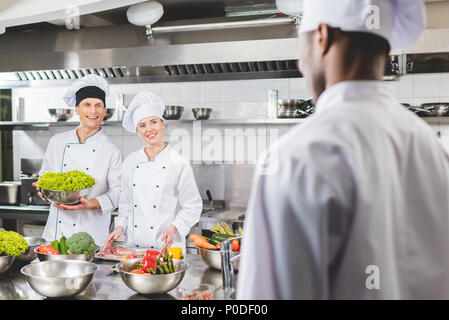 Lächelnd multikulturellen Köche im Restaurant Küche suchen Stockfoto