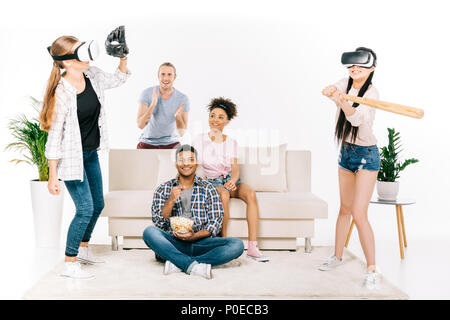 Jungen multiethnischen Freunde in der virtuellen Realität Headsets spielen Baseball isoliert auf weißem Stockfoto