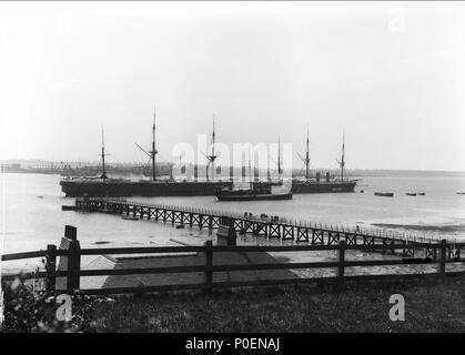 . Englisch: eine Ansicht aus Shotley über den Fluss Stour nach Harwich mit shotley Pier und das 'Training Ganges" Schiffe. Eine Ansicht aus Shotley über den Fluss Stour nach Harwich mit shotley Pier in den Vordergrund und Ganges die Ausbildung Schiffe'' (ex-'Minotaur') (1863), 'Caroline' (1882) und "Ganges II' (ex-'Agincourt") (1865) bei moorings. Eine Ansicht aus Shotley über den Fluss Stour nach Harwich mit shotley Pier und das 'Training Ganges" Schiffe. . 1906. Smiths Suitall Ltd 241 eine Ansicht aus Shotley über den Fluss Stour nach Harwich mit shotley Pier und das 'Training Ganges" Schiffe. RMG-P 27497 Stockfoto