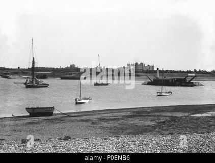 . Englisch: Ein Blick von der Felixstowe Ufer mit Blick über den Fluß Deben zu Bawdsey mit bawdsey Manor im Hintergrund. Ein Blick von der Felixstowe Ufer mit Blick über den Fluß Deben zu Bawdsey mit bawdsey Manor im Hintergrund. Der Dampf Kette Fähre 'Lady Quilter" (1894) gesehen Überfahrt auf die felixstowe Seite werden kann. Die andere Fähre, "Die Lady Beatrice' (1894), ist der Service Strände auf der Bawdsey Vorland. Drei Ipswich registrierte offene Boote stehen im Vordergrund: IH 169 ist ausgetrocknet an der Küste, und IH170 und IH177 sind flott verankert. Im mittleren Strom können zwei gaff - rigg gesehen werden. Stockfoto