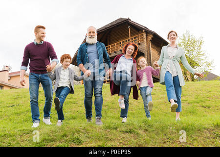 Glückliche Familie Hand in Hand zusammen, während in der Nähe von Country Haus im Dorf Stockfoto