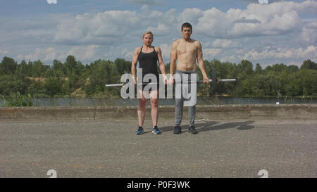 Junge glücklich Sport paar Arbeiten mit Langhantel zusammen Stockfoto