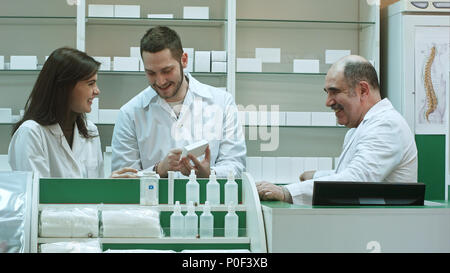 Positive Team von Apothekern in der Box von Tablet in der Krankenhausapotheke suchen Stockfoto