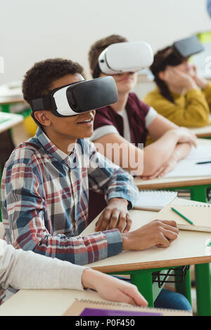 Multiethnischen High School Kursteilnehmer mit Virtual reality Headsets im Klassenzimmer Stockfoto