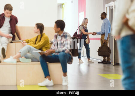 Multiethnische Gruppe von Schülerinnen und Schüler die Zeit an der Schule Korridor in der Pause Stockfoto