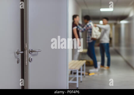 Unscharfer schuss Schüler gemobbt, von den Mitschülern in der Schule Korridor Stockfoto