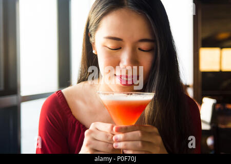 Asiatische Mädchen in einen Cocktail in einer Bar Stockfoto